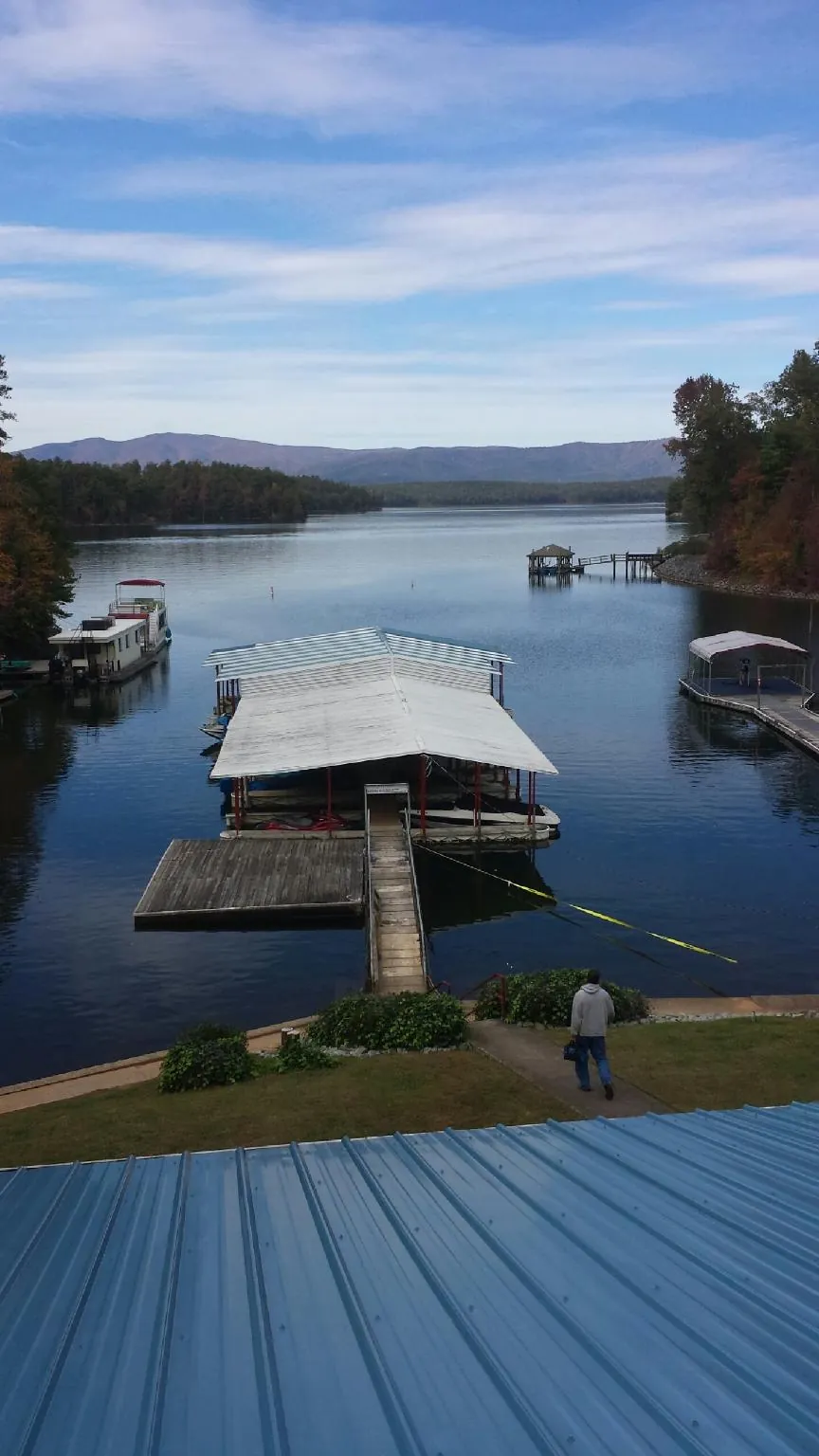View across a lake from a newly installed blue metal roof in Wauregan