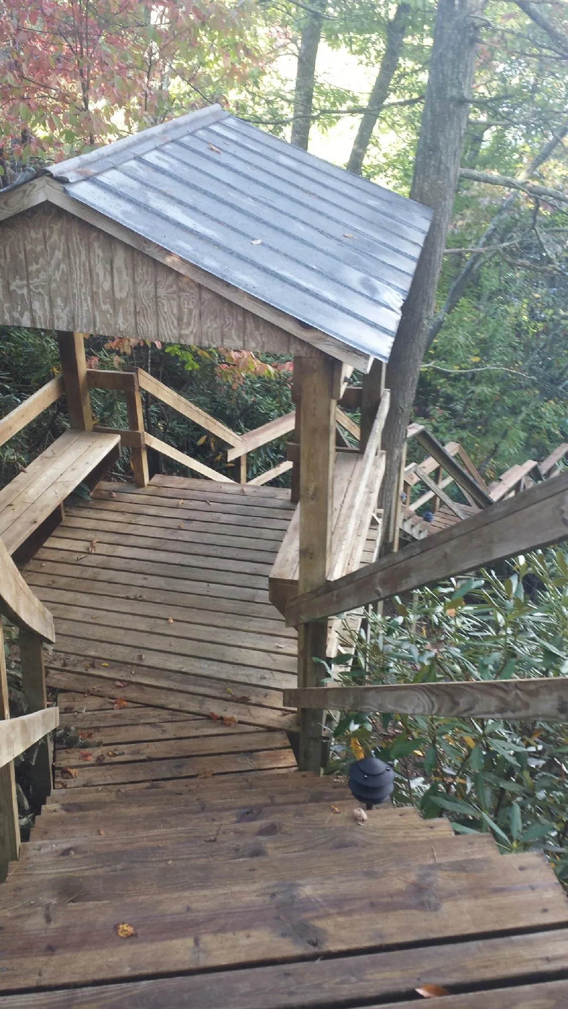 Metal roofed shelter over wooden steps on a wooded walkway — Skylight Repair & Installation work by our crew in Wauregan
