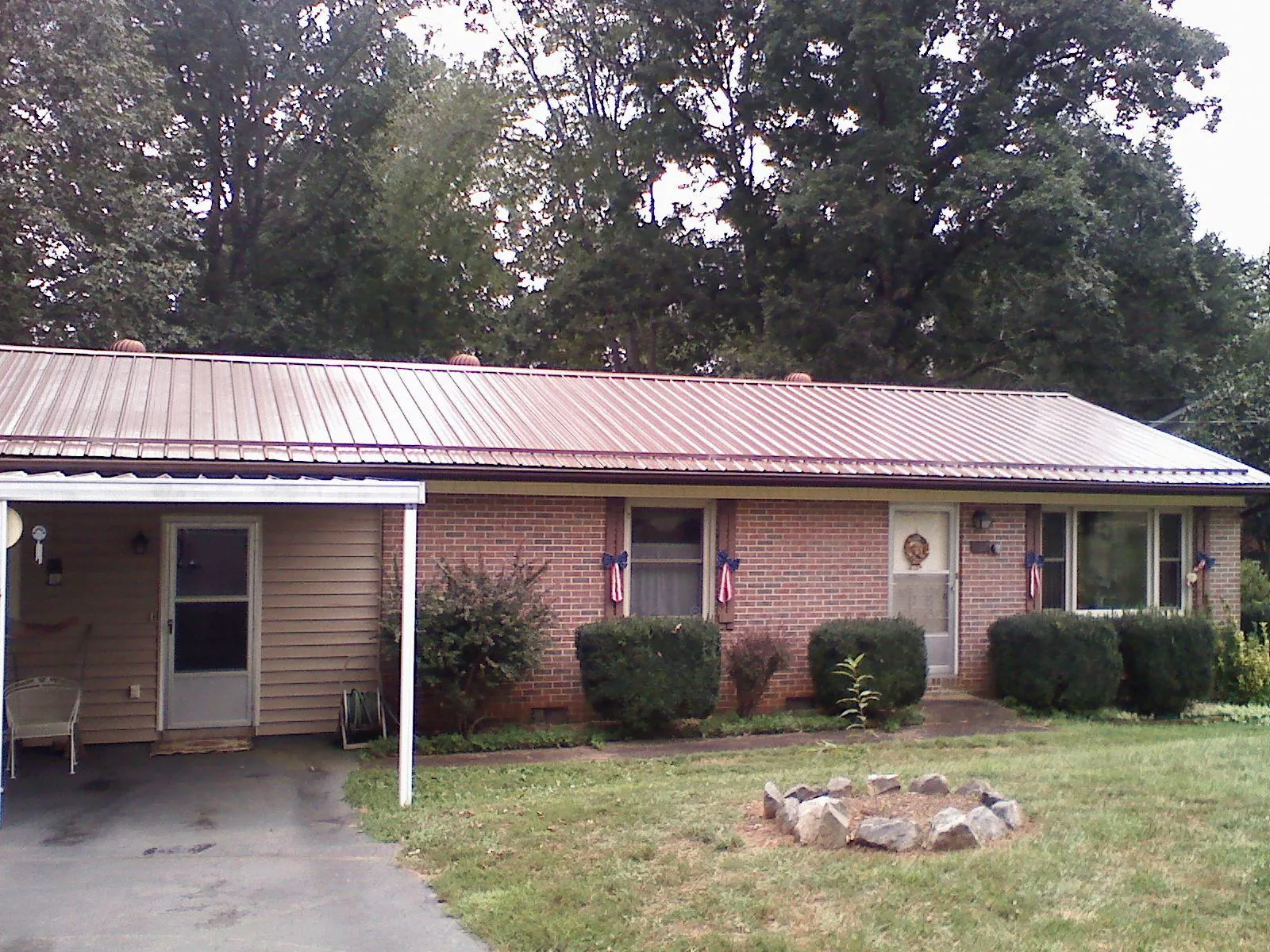 Bronze metal roof and carport on a brick ranch home — Roof Repair work by our crew in Wauregan